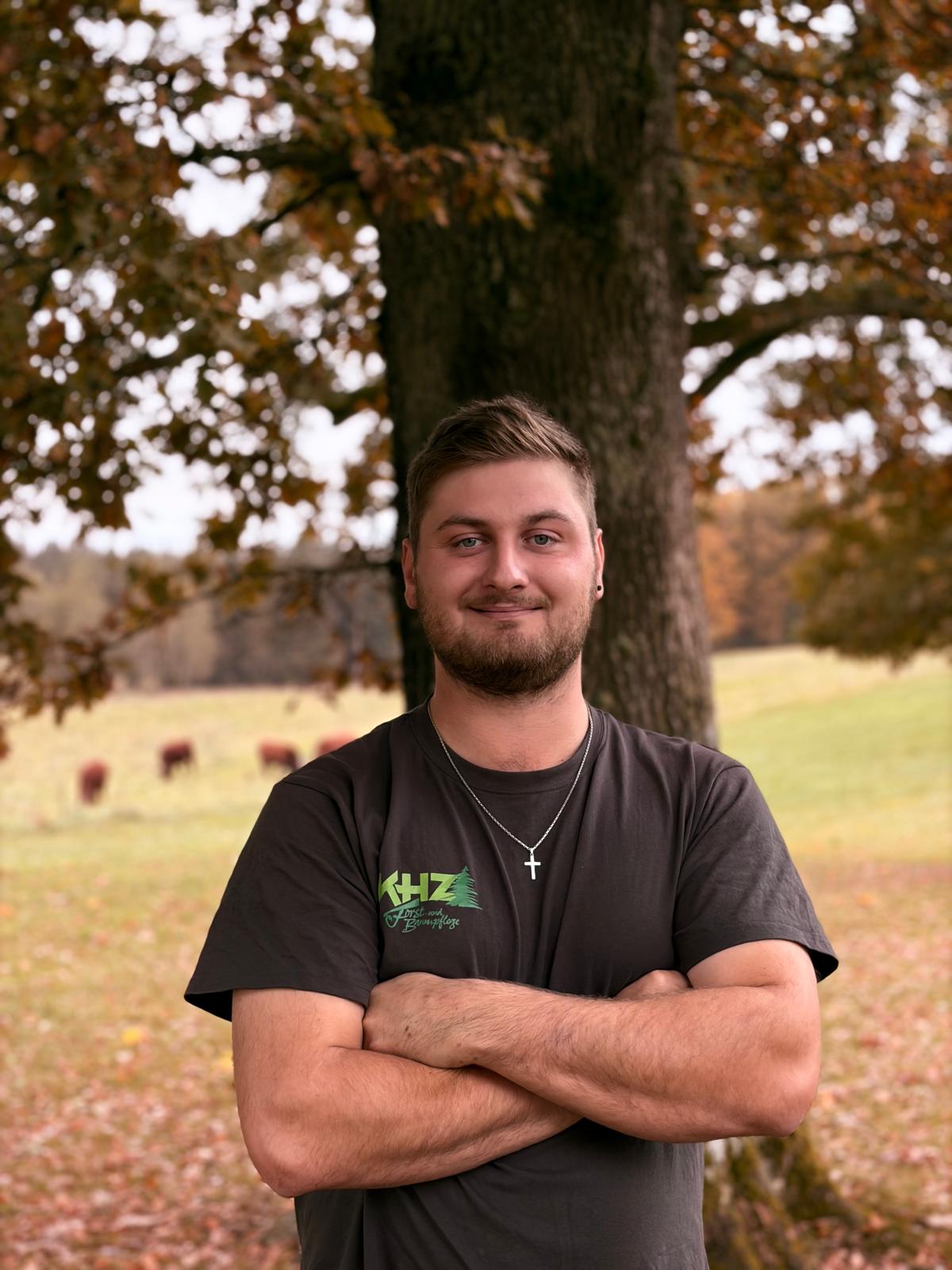 Franziskus Hugel im KHZ-Shirt vor einem Baum