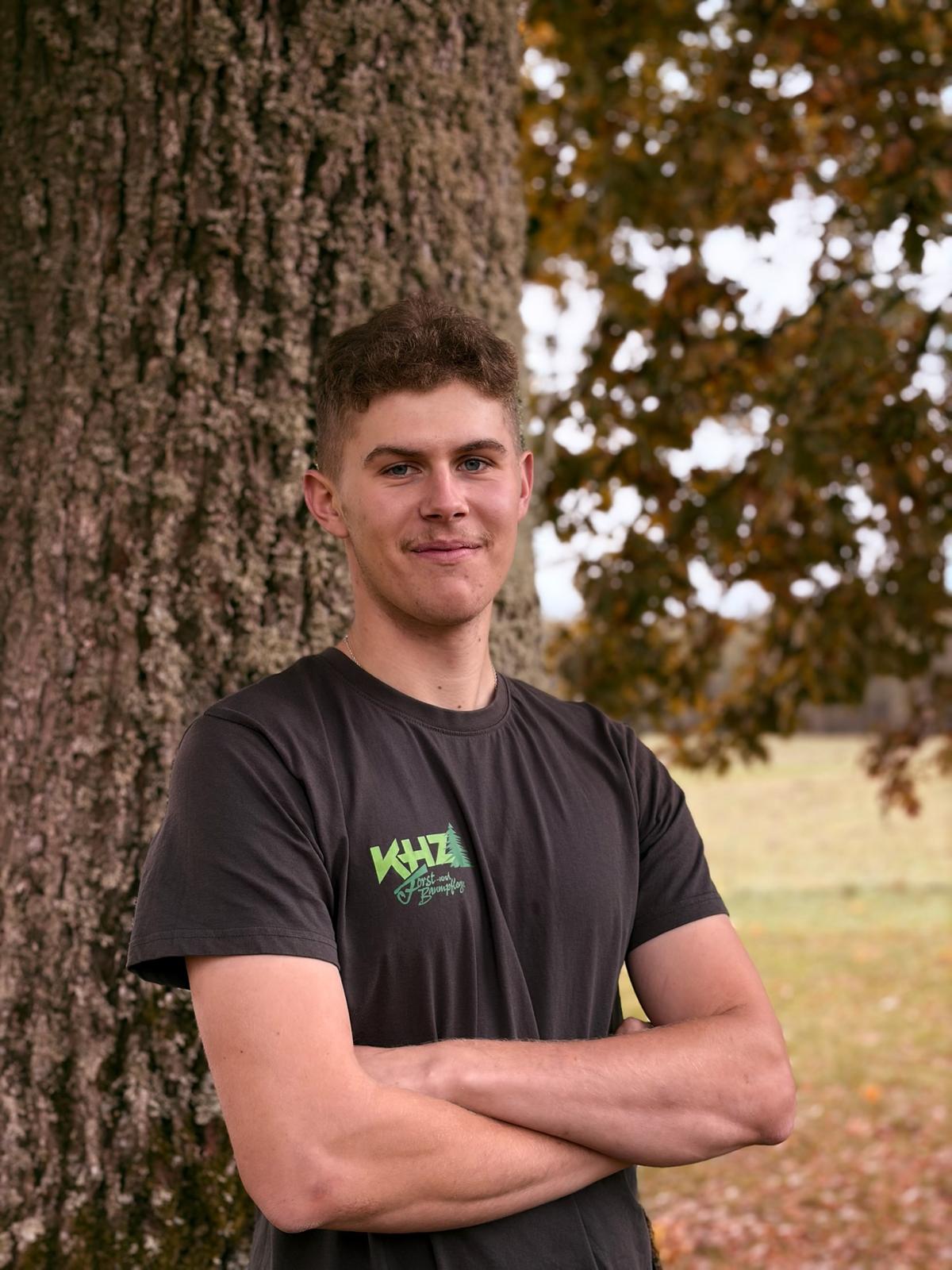 Quentin Zangenfeind im KHZ-Shirt neben einem Baum